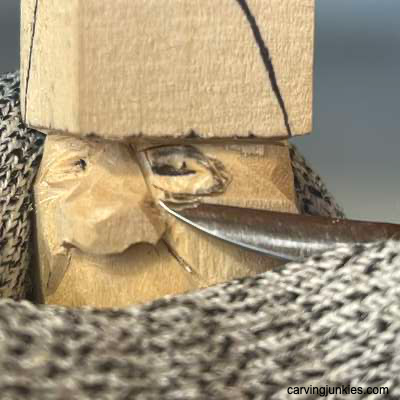 Meeting cuts under eyeline on acorn wood carving caricature