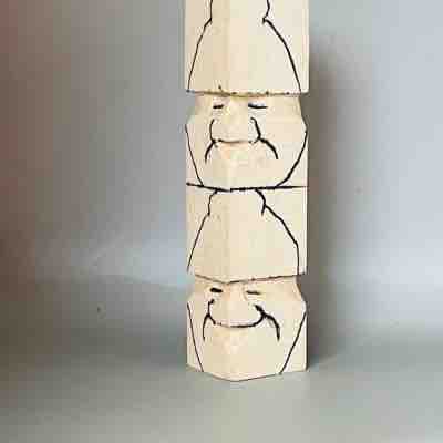 Faces are sketched on acorn wood carving caricature