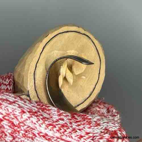 Using spoon carving knife to carve coffee scoop