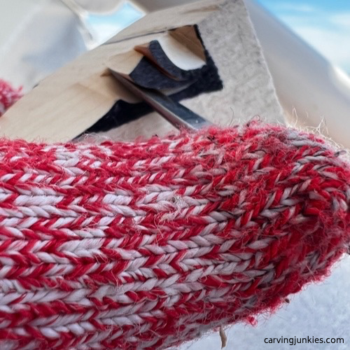 Removing layers of wood on carved old man
