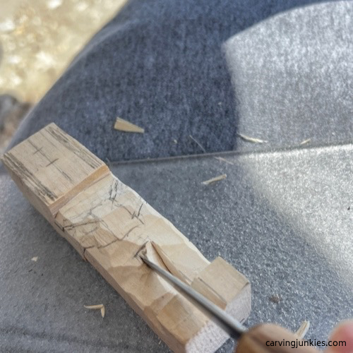 Removing excess wood on carved old man