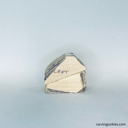 Left side of wood carved fortune cookie is marked for shaping