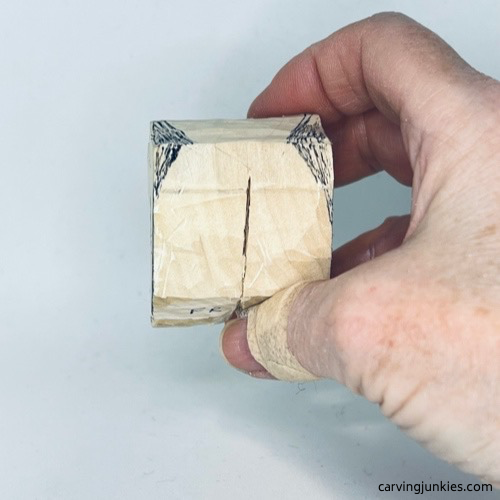 Top of wood carved fortune cookie is marked for shaping