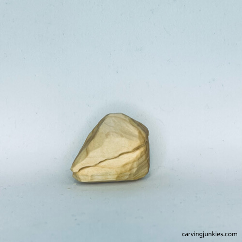 Left side of unpainted wood carved fortune cookie