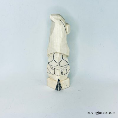 Details are sketched on front of wooden Christmas gnome