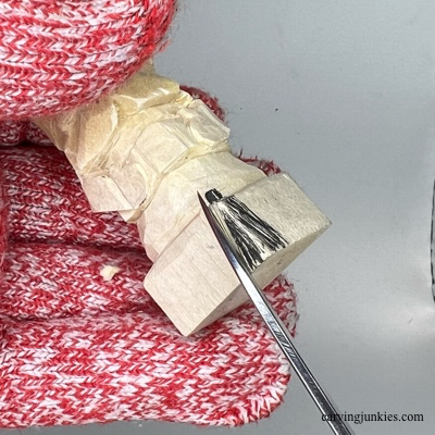 Making a V-cut to separate legs on wooden Christmas gnome carving