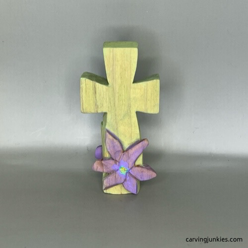 Completed back side of pastel colored hand carved cross with raised flower
