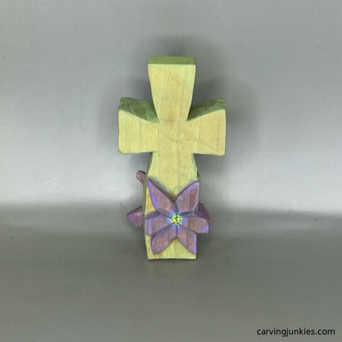 Front of finished pastel-colored wood carved cross with raised flower