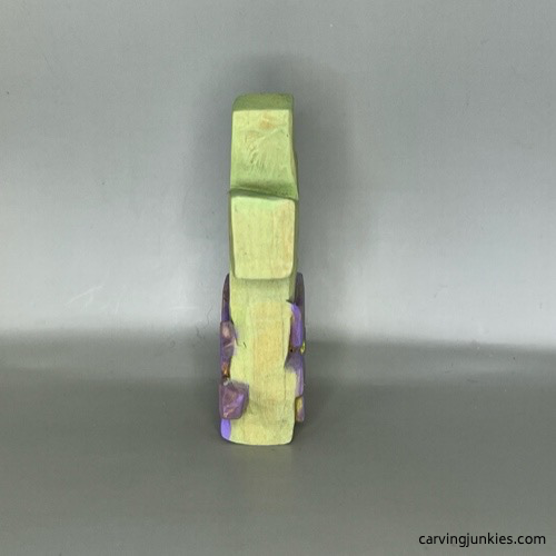 Right side of completed hand carved cross painted with pastel green, purple, and blue colors