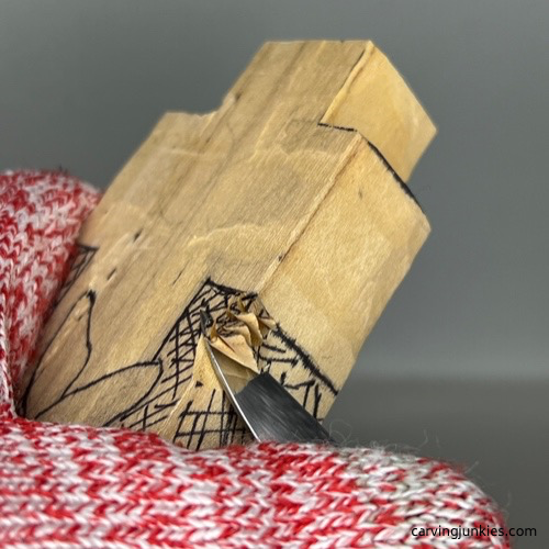 Using Helvie knife to remove wood to shape the bottom of a cross