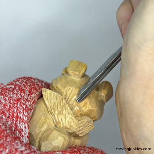Using gouge on carved wooden dog
