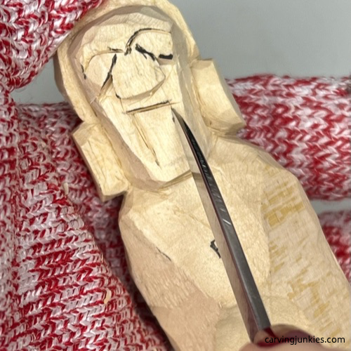 Carving mouth on earworm caricature carving