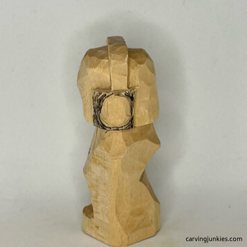 Oval on left side of earworm caricature carving