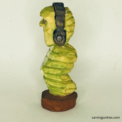 Left view of painted earworm caricature carving