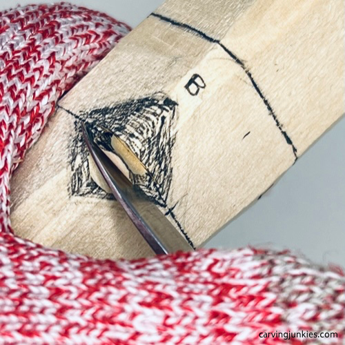 Making a stop cut on earworm caricature carving