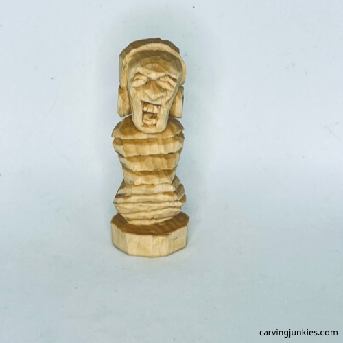 Unpainted front of earworm caricature carving