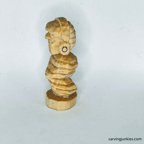 Unpainted left side of earworm caricature carving