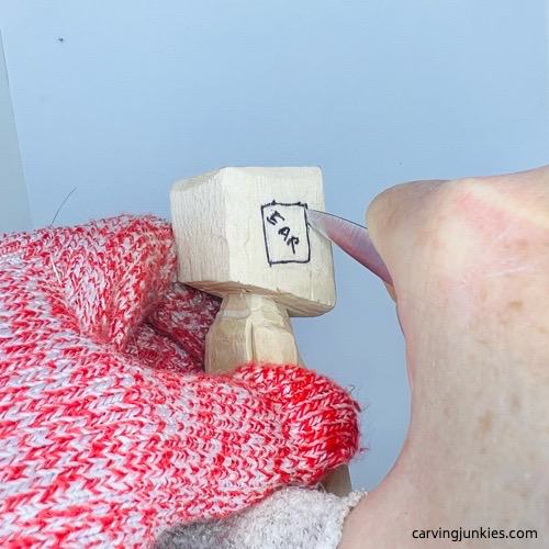 Cutting right ear on screw-up fairy wood caricature Carving right ear on screw-up fairy wood caricature