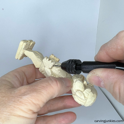 Using pin voice to make a hole on screw-up wood fairy caricature Drilling hole in hand on screw-up wood fairy caricature