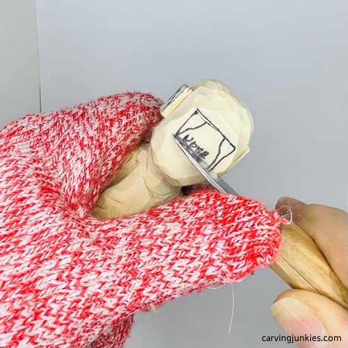 Carving nose on screw-up fairy wood caricature Making a stop cut on nose of screw-up fairy wood caricature