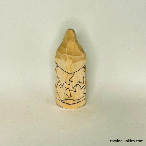 Leaves sketched on back of wood carved autumn gnome Details on back of wood carved fall gnome