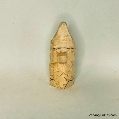 Details are sketched on wood carved autumn gnome More guidelines are drawn on wood carved fall gnome