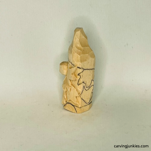 Left view of details on wood carved autumn gnome Left details are drawn on fall gnome wood carving