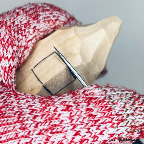 Using wood carving knife to make a stop cut on fall gnome Making stop cut to carve nose on fall gnome wood carving