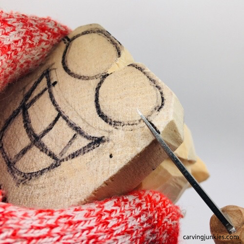 Carving eyes on wooden fish carving