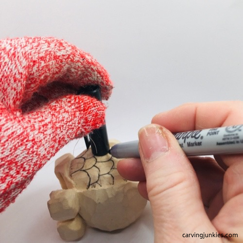 Drawing scales on wooden fish carving