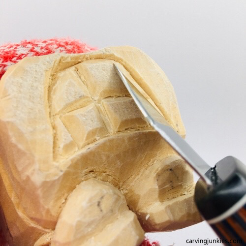 Shaping teeth on wooden fish carving