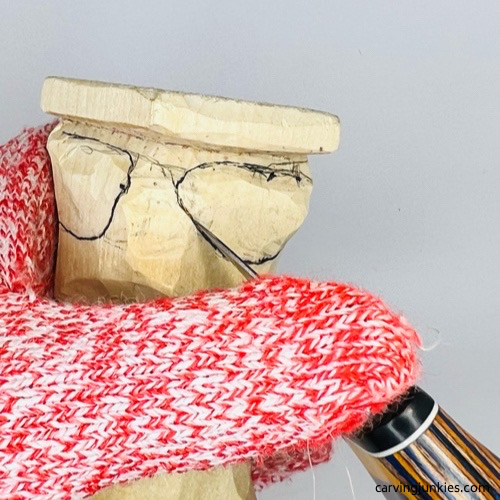 Cutting back legs of frog wood carving