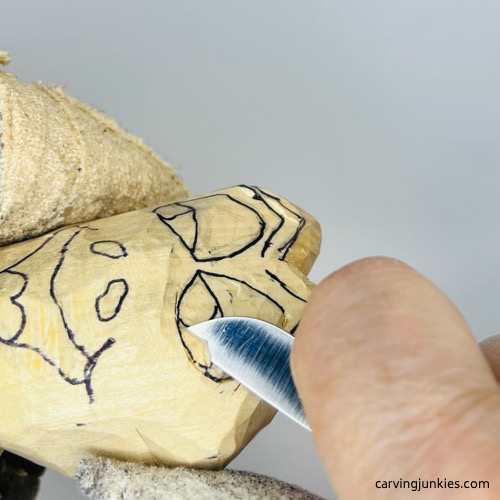 Carving eyes on frog wood carving