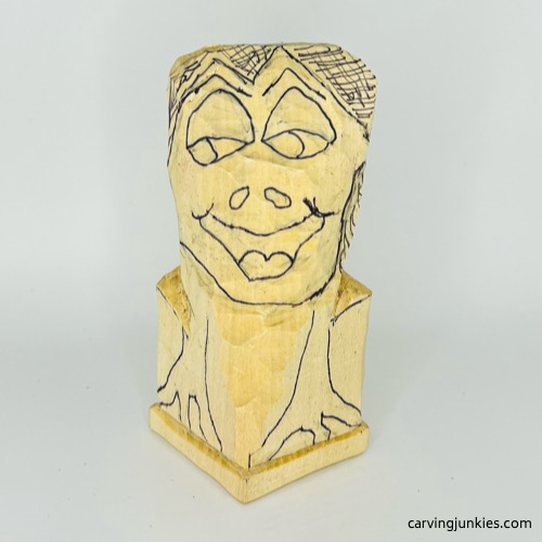 Drawn face on frog caricature carving