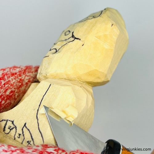 Shaping sides of wooden frog carving