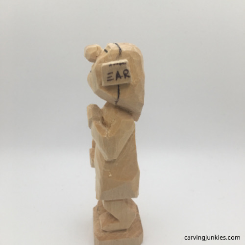 Left view of hands on female wood carving