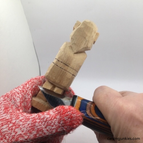 Cutting back legs on female wood carving