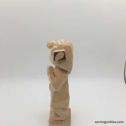 Left view of shaped ear on female wood carving