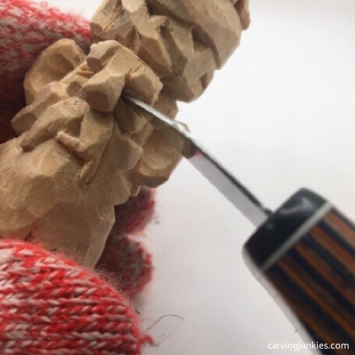 Carving eyes on wooden gnome