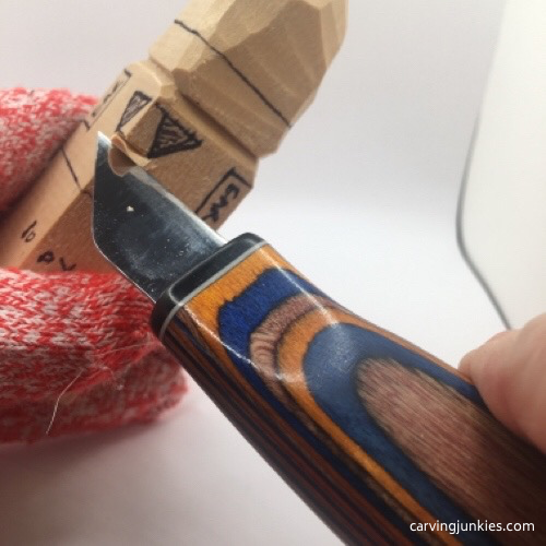 Carving a nose on wooden gnome