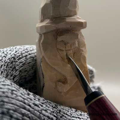 Carving details on hillbilly from wood