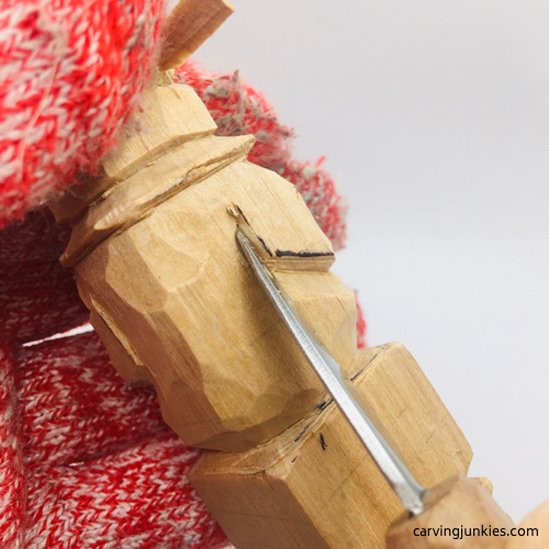 Carving back arm on wooden leprechaun