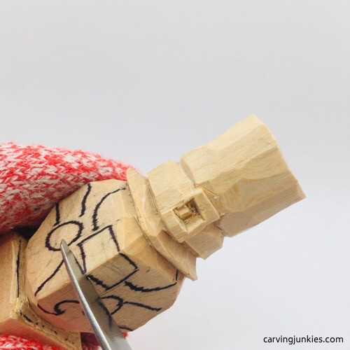 Carving nose on wood leprechaun