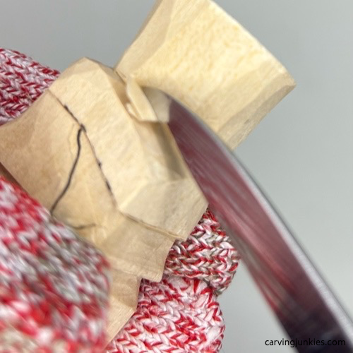 Carving hat on little wood carving