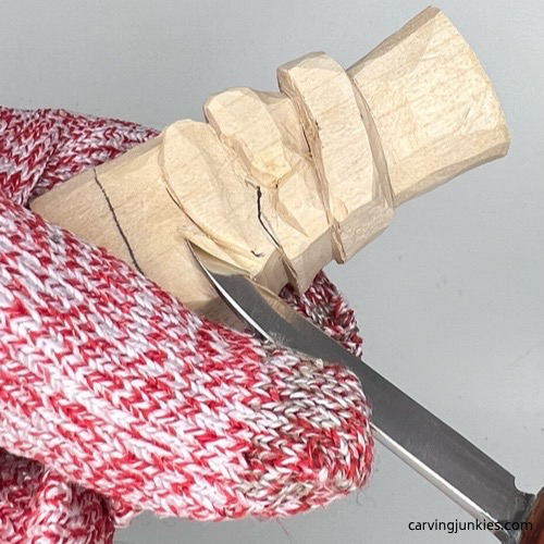 Carving mustache on little wood carving