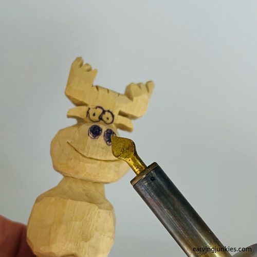Burning wood on moose carving Using wood burner on moose carving