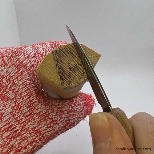Carving moose head with knife Cutting head of wooden moose