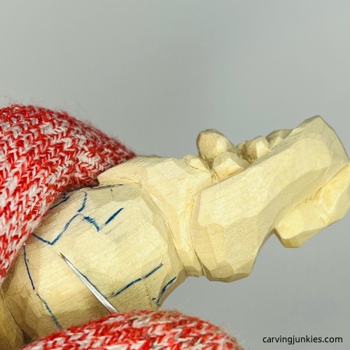 Making stop cut to separate arm on nisse carving