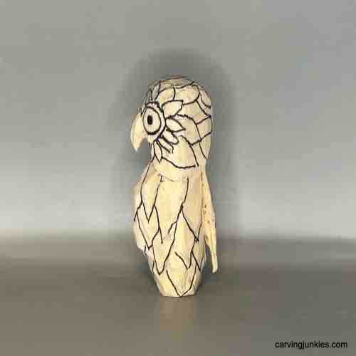 Discover the art of crafting a wooden owl with our tutorial. Left view of feathers on owl carving