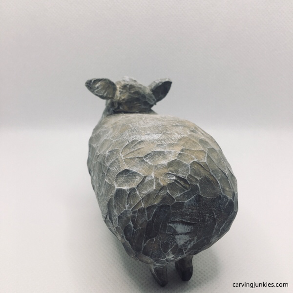Back view of painted sheep carving